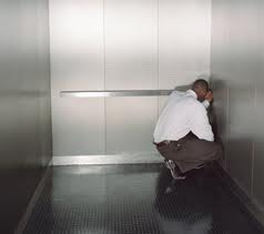 Guy Cowering In Elevator Corner